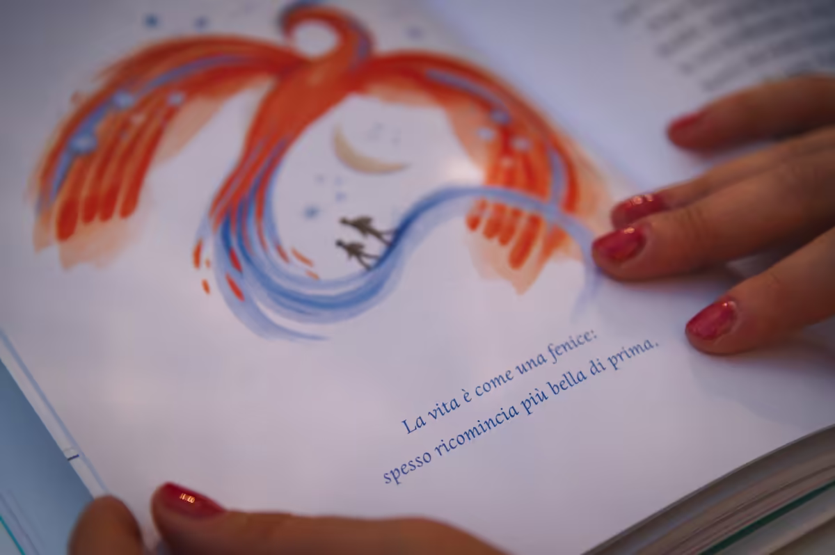 libro aperto su un passaggio che recita: la vita è come una fenice, spesso ricomincia più bella di prima